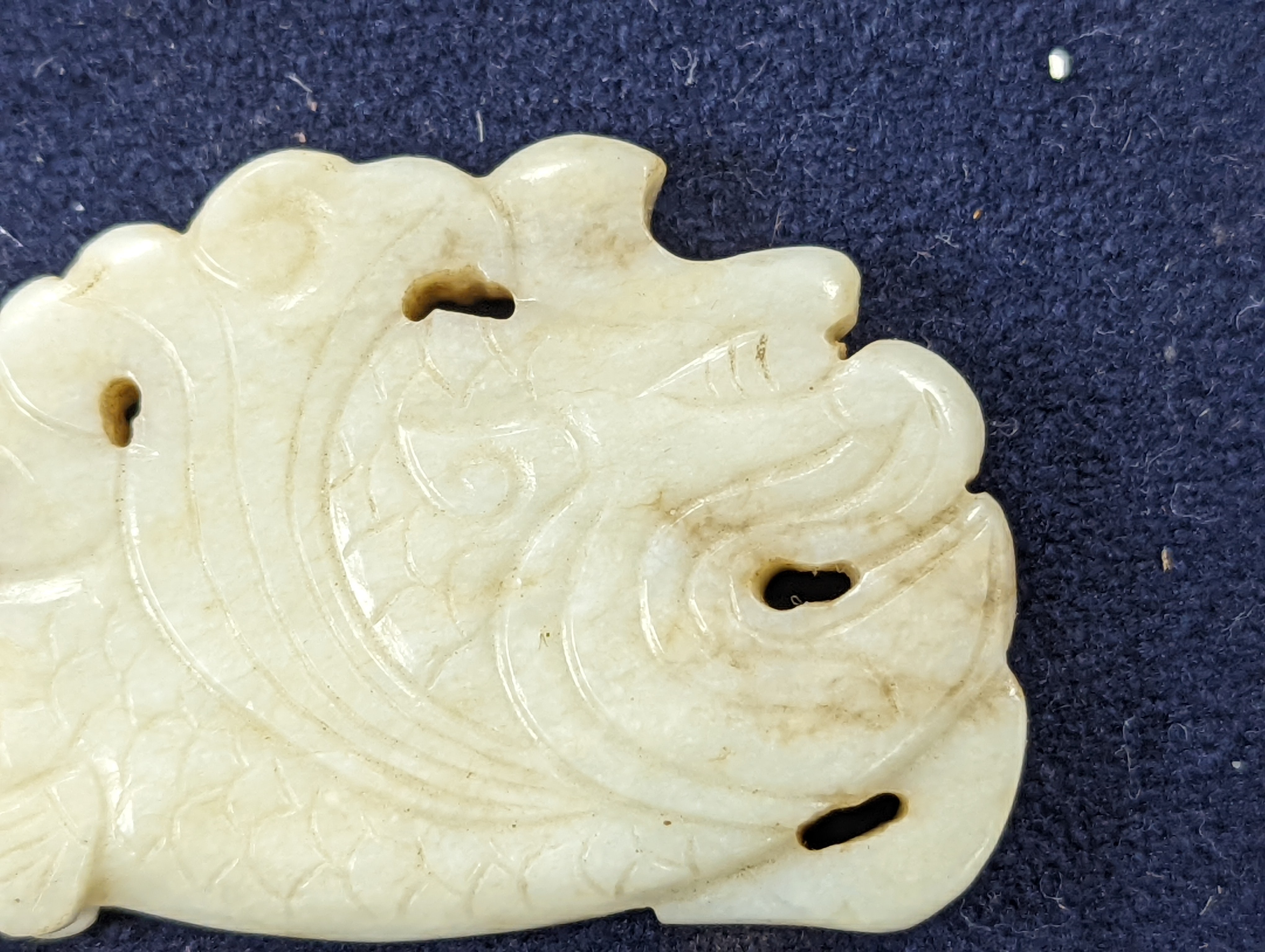 A Chinese white and black jade ‘dragon-fish’ plaque, 19th/20th century, 6cm